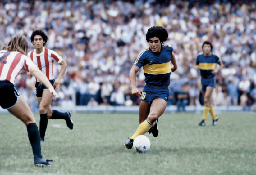 Junger Diego Maradona dribbelt mit dem Ball im Trikot von Boca Juniors