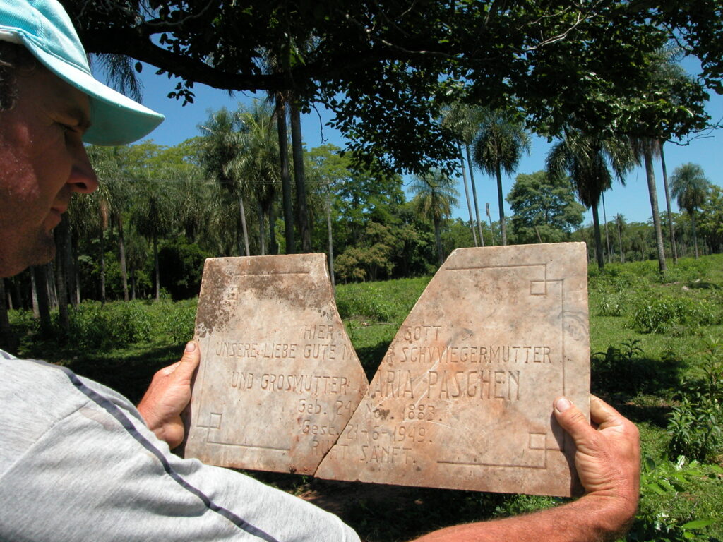 Person hält historische Gedenkplatte aus der Gründungszeit von Nueva Germania.